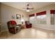 Comfortable living room with tile floors, ceiling fan, and natural light from the large windows at 10242 E Pantera Ave, Mesa, AZ 85212
