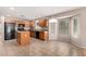 Well-lit kitchen with island, tile floors, breakfast nook, black appliances, and wood cabinetry at 1071 E Chelsea Dr, San Tan Valley, AZ 85140