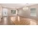 Bright living room featuring laminate wood flooring, modern ceiling fan, and a decorative chandelier at 1071 E Chelsea Dr, San Tan Valley, AZ 85140