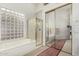 Bright bathroom featuring a glass block shower, a soaking tub, and mirrored closet doors at 10869 E Hedgehog Pl, Scottsdale, AZ 85262