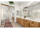 Bright bathroom featuring a glass block shower, double sinks, and mirrored closet doors at 10869 E Hedgehog Pl, Scottsdale, AZ 85262