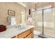 Well-lit bathroom with glass shower and wood cabinets at 10869 E Hedgehog Pl, Scottsdale, AZ 85262