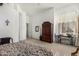 Cozy bedroom features a floral bedspread, large wardrobe, and window with plantation shutters at 10869 E Hedgehog Pl, Scottsdale, AZ 85262