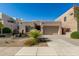 A tan home with xeriscaping and native plants, a stone facade, and an attached two-car garage at 10869 E Hedgehog Pl, Scottsdale, AZ 85262