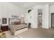 Bedroom with patterned bedding, neutral carpet, high ceilings, and a view into an adjoining bathroom at 10869 E Hedgehog Pl, Scottsdale, AZ 85262