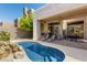 Backyard pool with rock waterfall, covered patio, BBQ grill, and outdoor seating at 10869 E Hedgehog Pl, Scottsdale, AZ 85262