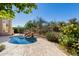Backyard pool with rock waterfall feature and desert landscape with patio dining at 10869 E Hedgehog Pl, Scottsdale, AZ 85262