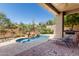 Beautiful pool with natural rock feature in desert landscape, covered patio, and lounge chairs at 10869 E Hedgehog Pl, Scottsdale, AZ 85262