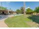 A sprawling backyard is complete with a large pool, green grass, and mature trees at 11051 N 45Th Pl, Phoenix, AZ 85028