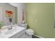 Powder room features green walls, a white single sink vanity, framed art, and a comfort height toilet at 11051 N 45Th Pl, Phoenix, AZ 85028