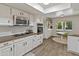 A modern kitchen features stainless steel appliances, white cabinets, and natural light from an adjacent breakfast nook at 11051 N 45Th Pl, Phoenix, AZ 85028