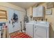 Bright laundry room offers washer and dryer, utility sink, and storage solutions at 11051 N 45Th Pl, Phoenix, AZ 85028