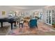 Inviting living room boasts a grand piano, colorful rug, and plenty of seating at 11051 N 45Th Pl, Phoenix, AZ 85028