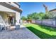A lush artificial lawn and charming seating area accent this home's backyard, enclosed by a block wall for privacy at 1140 E Vermont Dr, Gilbert, AZ 85295