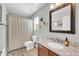 Bathroom with wooden cabinets, granite counters, toilet, and shower with curtain at 1140 E Vermont Dr, Gilbert, AZ 85295