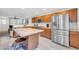 Bright and open kitchen featuring a large island, stainless steel appliances, tile backsplash, and wood cabinets at 1140 E Vermont Dr, Gilbert, AZ 85295