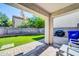 Covered patio featuring stone pavers, a grill, and an artificial lawn in a landscaped backyard at 1140 E Vermont Dr, Gilbert, AZ 85295
