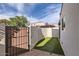 Private backyard featuring artificial grass, brick pavers, and a secure gate at 1147 E Belmont Ave, Phoenix, AZ 85020