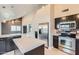 Modern kitchen featuring stainless steel appliances, dark cabinetry, and a bright center island at 1147 E Belmont Ave, Phoenix, AZ 85020