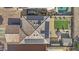 Aerial view of house featuring solar panels, backyard patio, artificial grass, and nearby swimming pool at 11915 W Charter Oak Rd, El Mirage, AZ 85335