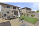 Large backyard featuring artificial grass, dining set, and a built-in fire pit, ideal for outdoor entertaining at 11915 W Charter Oak Rd, El Mirage, AZ 85335