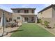 Spacious backyard featuring artificial turf, low maintenance desert landscaping, and covered patio for outdoor dining at 11915 W Charter Oak Rd, El Mirage, AZ 85335