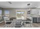 Bright dining area with a large table, modern lighting, and a view of the backyard through sliding glass doors at 11915 W Charter Oak Rd, El Mirage, AZ 85335