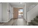 Bright foyer with wood-look floors, security door, coat closet, and staircase to the second floor at 11915 W Charter Oak Rd, El Mirage, AZ 85335