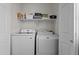 Efficient laundry room featuring a modern washer and dryer with ample storage shelves above at 11915 W Charter Oak Rd, El Mirage, AZ 85335