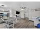 Bright living room featuring hardwood floors, a dining table, a modern TV, and a comfortable white couch at 11915 W Charter Oak Rd, El Mirage, AZ 85335