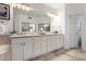Bright bathroom features double sinks with white cabinetry and travertine flooring at 15215 S 20Th Pl, Phoenix, AZ 85048