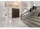 Grand foyer with high ceilings, marble floors, staircase, large window and a beautiful wooden double door at 15215 S 20Th Pl, Phoenix, AZ 85048