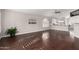 Bright living room featuring hardwood floors, neutral paint, and a view into the kitchen with white cabinets at 15215 S 20Th Pl, Phoenix, AZ 85048