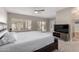 Bright main bedroom with a ceiling fan, plantation shutters, and an ensuite bathroom at 15215 S 20Th Pl, Phoenix, AZ 85048