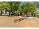 Extensive backyard with mature trees providing shade and a circular patio at 15610 N 98Th Ave # 26, Sun City, AZ 85351