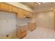 Bright kitchen featuring wood cabinets, white appliances, tile floors and access to the dining area at 15610 N 98Th Ave # 26, Sun City, AZ 85351