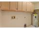 Laundry area featuring upper cabinets, utility hookups and a hot water tank at 15610 N 98Th Ave # 26, Sun City, AZ 85351
