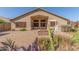 Backyard featuring a brick paved patio, desert landscaping, and stucco home exterior at 16605 W Pierce St, Goodyear, AZ 85338
