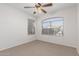 Cozy bedroom with neutral carpet, fan and large window for natural light at 16605 W Pierce St, Goodyear, AZ 85338