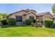 Attractive home with mature desert landscaping, a green lawn, and a neutral-colored exterior at 16605 W Pierce St, Goodyear, AZ 85338