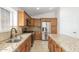 Kitchen featuring granite counters, stainless steel appliances, and ample storage in wooden cabinets at 16605 W Pierce St, Goodyear, AZ 85338