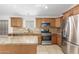 Well-equipped kitchen boasts granite countertops, stainless appliances, and wooden cabinetry at 16605 W Pierce St, Goodyear, AZ 85338