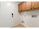 Functional laundry room with white door and upper cabinets at 16605 W Pierce St, Goodyear, AZ 85338
