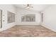 Bright living room with wood-look floors, ceiling fan, and ample natural light from many windows at 16605 W Pierce St, Goodyear, AZ 85338