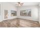 Bright living room featuring wood-look flooring, ceiling fans, and a glass door at 16605 W Pierce St, Goodyear, AZ 85338