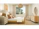 Stylish bedroom featuring a woven pendant light, neutral decor, and a comfortable armchair at 17375 W Whispering Wind Rd, Surprise, AZ 85387
