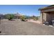 Wide backyard with gravel, block wall, pool, patio, and seating area at 1813 N Lewis Pl, Casa Grande, AZ 85122