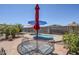 Inviting backyard patio featuring a pool, outdoor seating, and colorful umbrellas for shade at 1813 N Lewis Pl, Casa Grande, AZ 85122