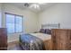 Cozy bedroom with hardwood floors, a ceiling fan, and large window for natural light at 1813 N Lewis Pl, Casa Grande, AZ 85122
