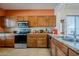 Traditional kitchen with stainless steel appliances, granite countertops, and wood cabinets at 1813 N Lewis Pl, Casa Grande, AZ 85122